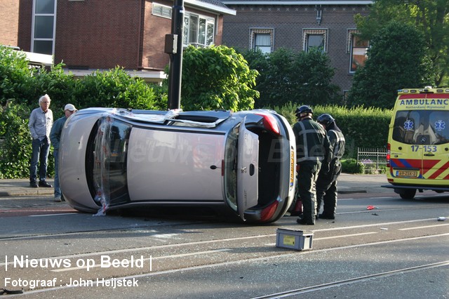 Auto op zijn kant na aanrijding Straatweg Rotterdam