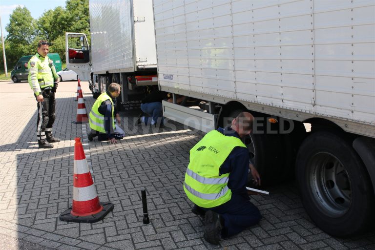 Vrachtwagenchauffeur met 7 gladde banden loopt tegen de lamp tijdens transportcontrole A44 bij Oegstgeest