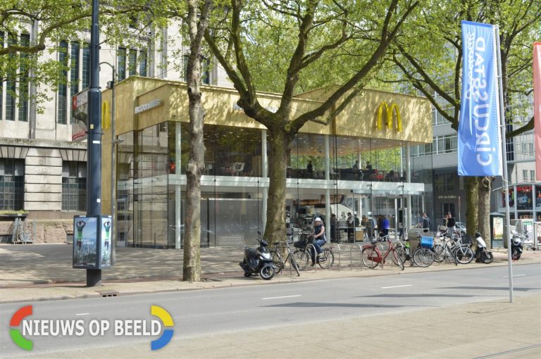Persoon belt 112 voor bacon op McDonalds burger in Rotterdam