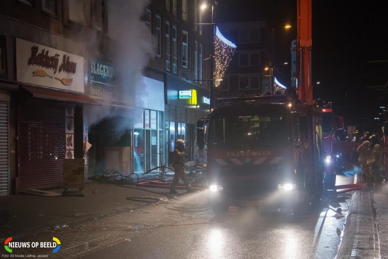 Brandweer redt bewoners uit huizen en van het dak na felle winkelbrand Schiedamseweg Rotterdam