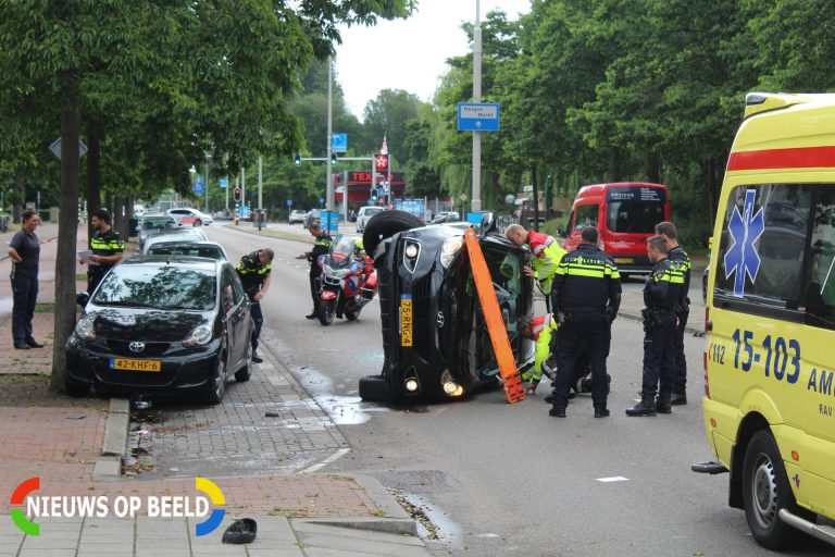Auto op zijn kant bij aanrijding Erasmusweg Den Haag