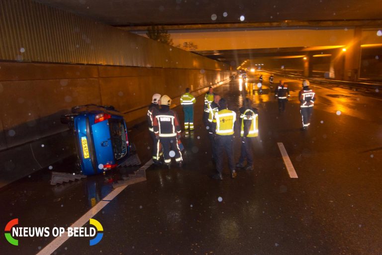 Auto op zijn kant door enorme plas water A20 Nieuwerkerk aan den IJssel