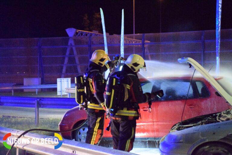 Omstanders blussen brandende auto De Andel Waddinxveen