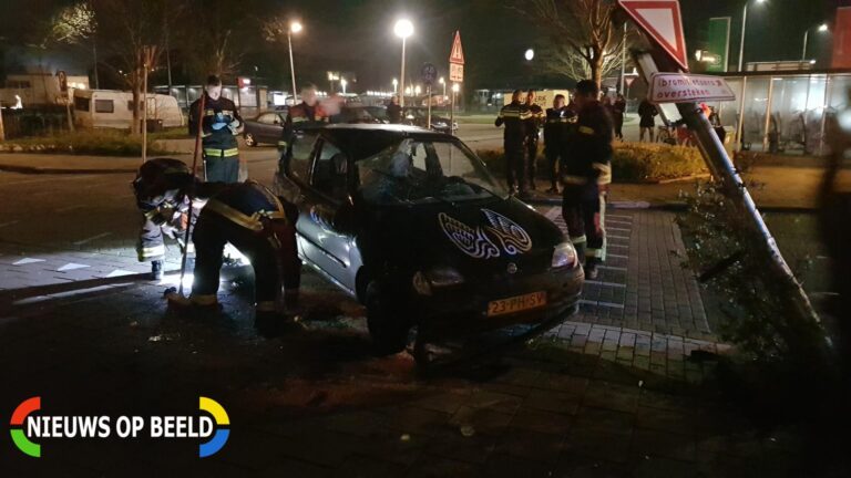 Auto op zijn kant na botsing met lantaarnpaal Parallelweg Bergambacht