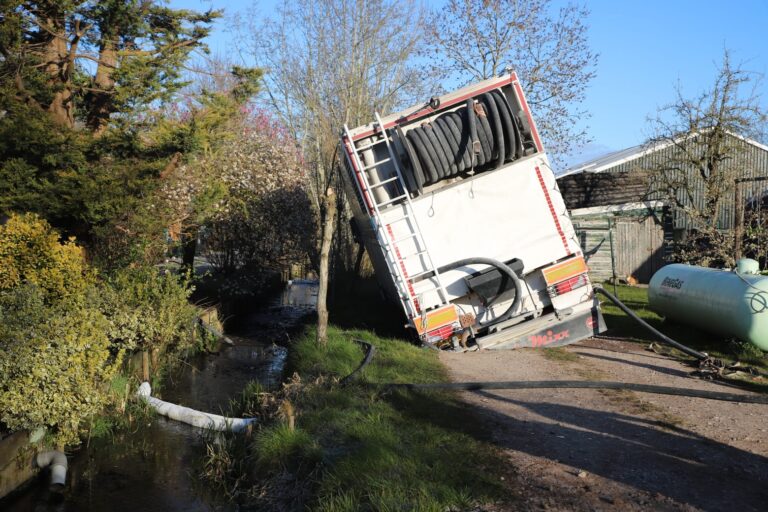 Vrachtwagen zakt weg op zandweg in Berkenwoude