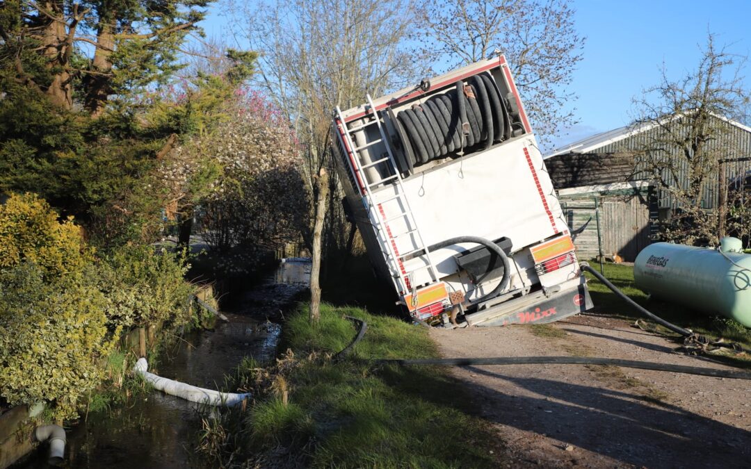 Vrachtwagen zakt weg op zandweg in Berkenwoude