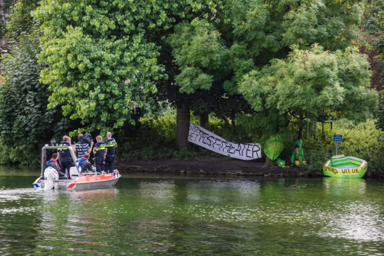 Politie haalt verklede demonstrante van eilandje in Haagse Hofvijver