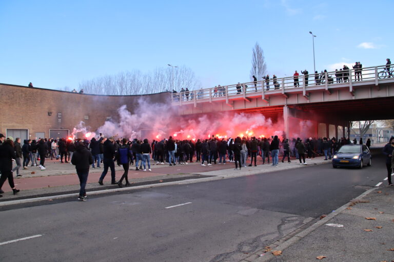 Feyenoordsupporters steunen het elftal met vuurwerk buiten het stadion, toch 17 relschoppers aangehouden