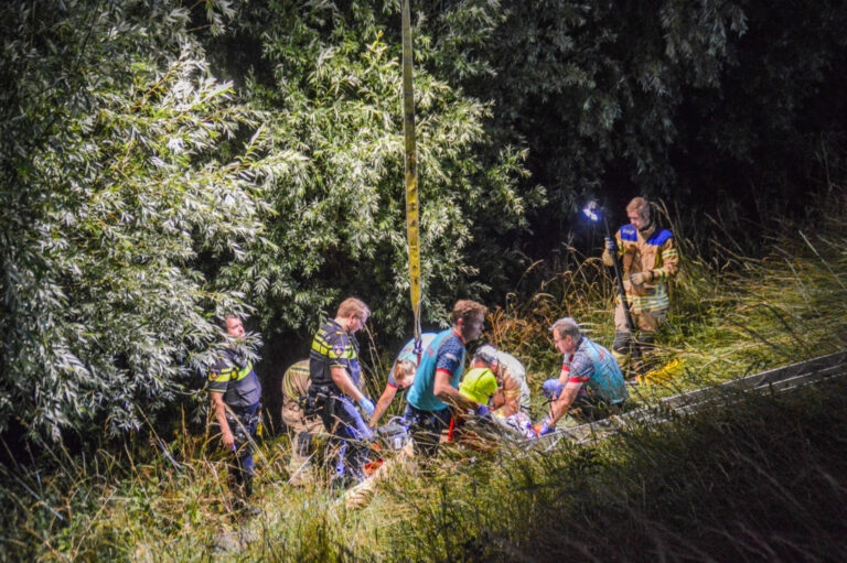 Voorbijganger hoort hulpgeroep en vindt man in water onder aan dijk