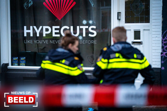 Kogelgaten in ruit barbershop na beschieting Schiedamseweg Rotterdam
