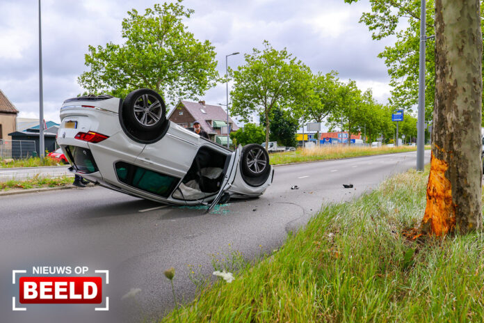 Auto over de kop na aanrijding met boom Hoofdweg Rotterdam